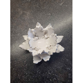Elegant ceramic candle holder with white leaf design and sphere candle.